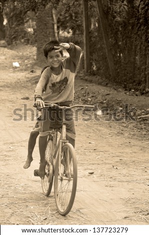 PHNOM PHEN, CAMBODIA MARCH 23: Unidentified street children biking on march 23 2013 in Phnom Phen,Cambodia.In Phnom Penh alone there are between 10,000 and 20,000 children live and work on the streets