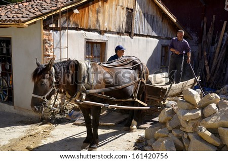 KOPRIVSHTITSA BULGARIA SEPTEMBER 25: Men restore old houses help by an horse on september 25 2013 in Koprivshtitsa  Bulgaria