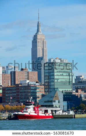 NEW YORK CITY, NY OCT 29: NYFD boat and the Empire State Building on oct. 29, 2013 in New York City. Fireboats with the greatest pumping capacity of any Fireboat in the world..