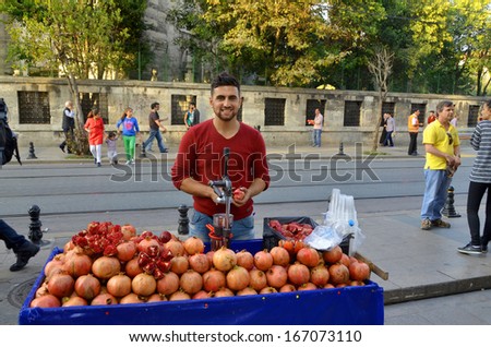 ISTANBUL TURKEY SEPT 28: Young man sells pomegranate juice for to live in down town Istanbul on september 28 2013. Pomegranate juice is one of the most popular in Turkey
