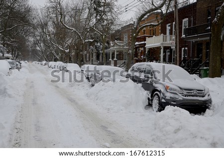 MONTREAL-CANADA DEC. 15:Cars cover of snow on Melrose Street. The snow storm slam Montreal with 35 cm of snow, Canada on Dec. 15, 2013. The winter storm, causing flight delays and traffic problems