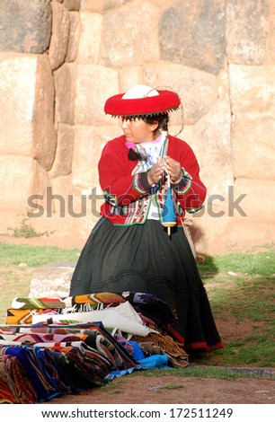 NEAR CUSCO PERU-NOVEMBER 15:Quechua woman dressed in traditional clothing sale colorful tablecloths and fabric on November 15, 2010 in Cusco Peru. The national rural poverty rate is over 50 per cent.