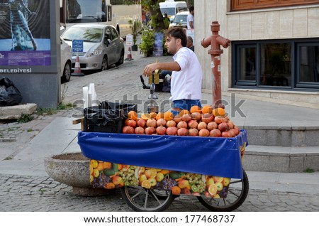 STANBUL TURKEY SEPT 28: Young man sells pomegranate juice for to live in down town Istanbul on september 28 2013. Pomegranate juice is one of the most popular in Turkey