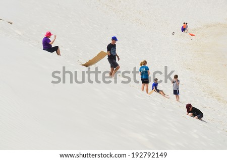 WHITE SANDS NM USA APRIL 24: People slide on sand at the White Sands National Monument  the largest gypsum dune field in the world. On april 24 2104 in White Sands NM USA
