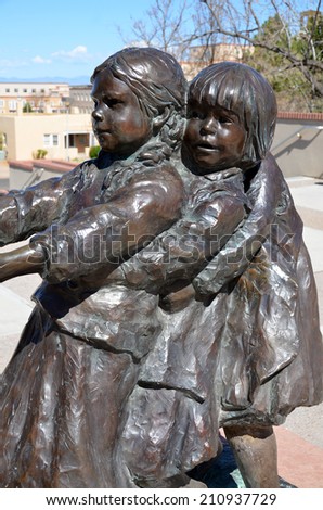 SANTA FE, NM USA APRIL 21: Bronze sculpture of three girls and two boys playing tug o\' war (without a rope) on april 21, 2014 in Santa Fe, NM. Glenna Goodacre Lubbock, Texas, 1939, American sculptress