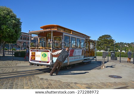 SAN FRANCISCO CA USA 04 16 2015: Operator manually turns a cable car in a right of way in San Fransisco CA USA. It is the oldest mechanical public transport in San Francisco which is in service since 1873