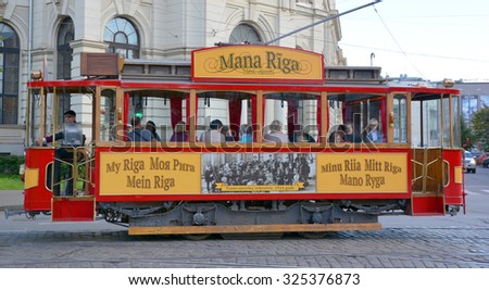 RIGA LATVIA 09 17 2015: Every Friday, Saturday, Sunday and holiday days, a restored tourist tram originally built in 1901 cruises Riga\'s streets. In front of the Latvian National Theater.