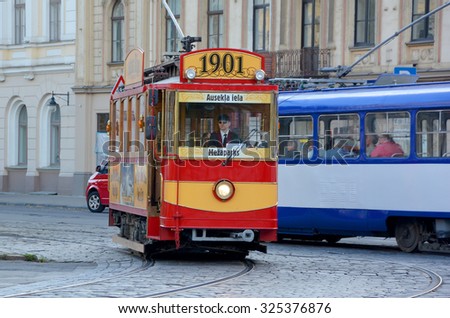 RIGA LATVIA 09 17 2015: Every Friday, Saturday, Sunday and holiday days, a restored tourist tram originally built in 1901 cruises Riga\'s streets. In front of the Latvian National Theater.