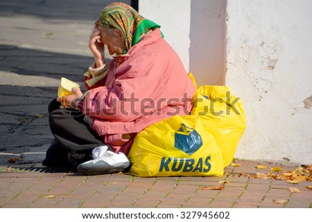 SIAULIAI LITHUANIA 09 17 2015: Poor old woman asking for money at the exit of a Church. Lithuania Population below poverty line 4% (2008)