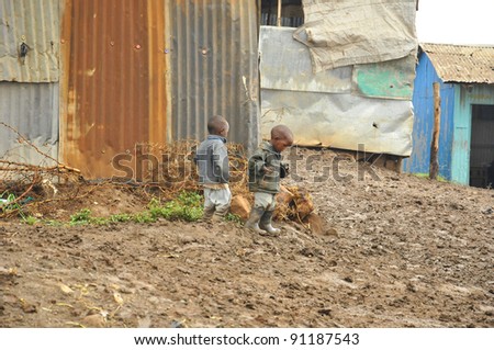 NAIROBI, KENYA OCT. 13: Unidentified people walk in mud through the Nairobi slum Oct. 13 2011 in Nairobi, Kenya. Kibera is the largest slum in Nairobi, and the second largest urban slum in Africa