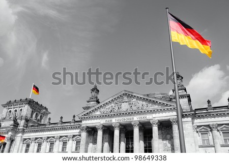 The German flag streaming in front of the German parliament building, the Reichstag at Berlin, Germany.