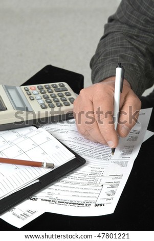 Close up of man\'s hand filling out income tax 1040 form.
