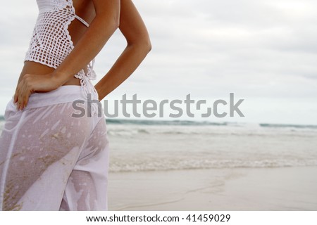 Back shot of beach beauty in wet white pants