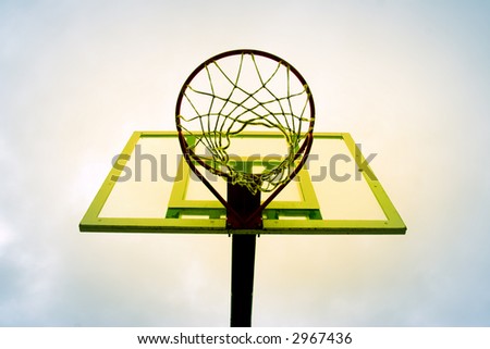 yellow basketball hoop against the blue sky.