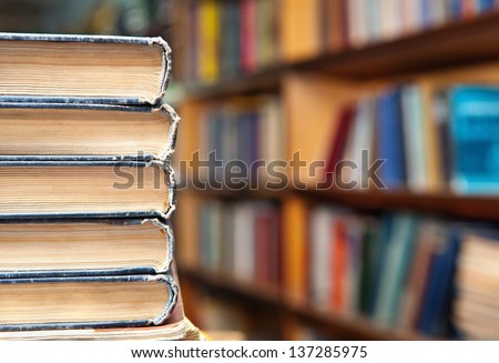 Book stack and book shelf in a library background