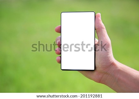 hand holding a smart phone device on a green background