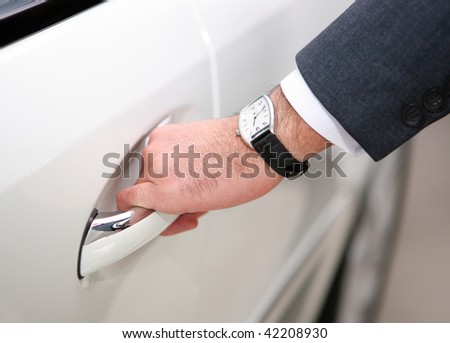 hand with watch opening luxury car door