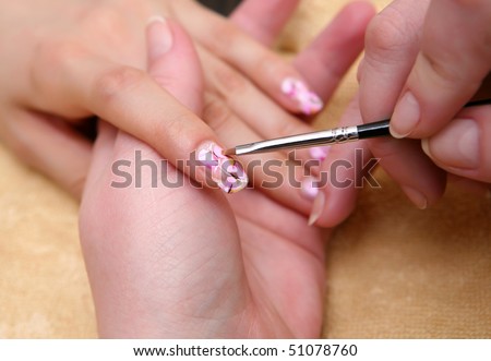 hands painting fingernails with a brush