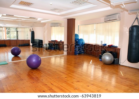empty fitness gym with mirrors and wooden floor