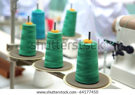 green reels of textile yarn thread at manufacturing machine.