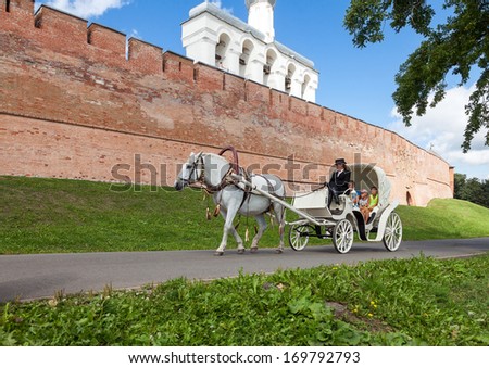 NOVGOROD VELIKY, RUSSIA - AUGUST 10, 2013: Horseback riding near the wall of Novgorod kremlin. Novgorod - famous ancient Russian city was founded in 859