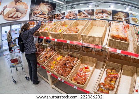 SAMARA, RUSSIA - OCTOBER 5, 2014: Young woman choosing fresh bakery products at shopping in supermarket store Magnit. Russia\'s largest retaile
