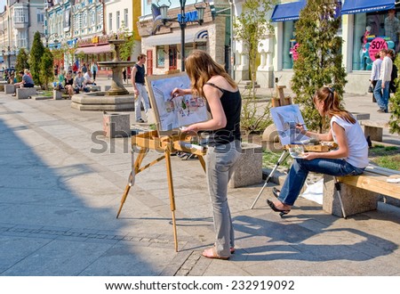 SAMARA, RUSSIA - MAY 5, 2014: Young artists drawing at the outdoors in sunny day