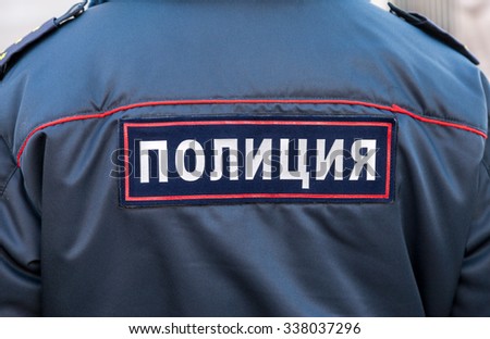 Midsection of russian policeman in uniform. Text on russian: \