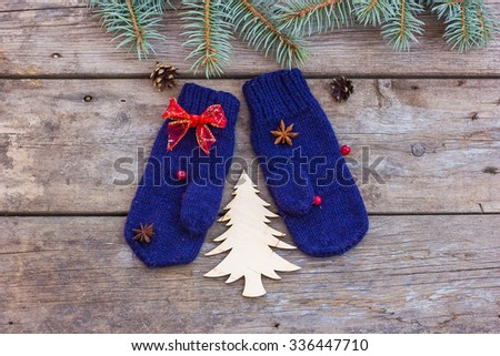 warm mittens on a wooden background, Christmas tree and decorations. Christmas concept