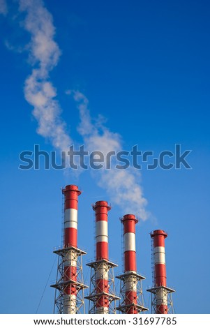Four factory chimney smoking  on a background blue Sky