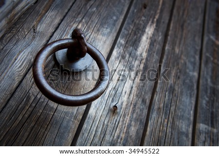 Old-fashioned ring door handle on old wooden hatch