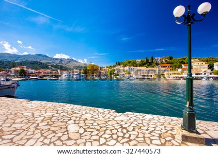 View of greek village port with a post light in the frame old houses in Corfu Island