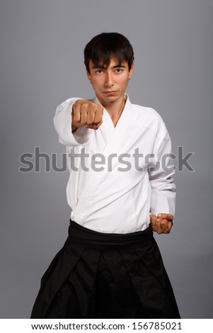 Bellicose man on grey background standing in fighting pose