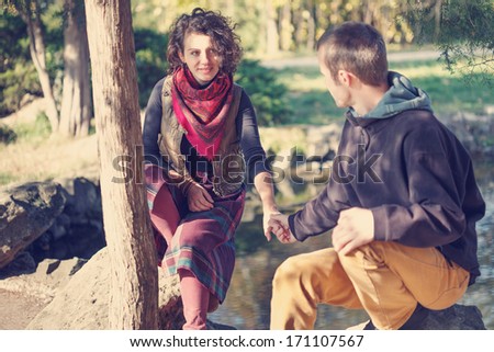 Loving couple in bright clothes meeting in the park near the lake