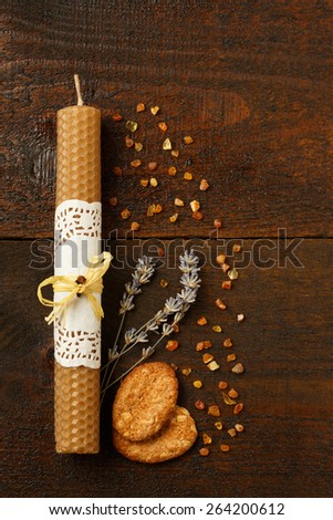 Still life with honey candle, oatmeal cookies, dried lavender and marine baltic amber on wooden table background