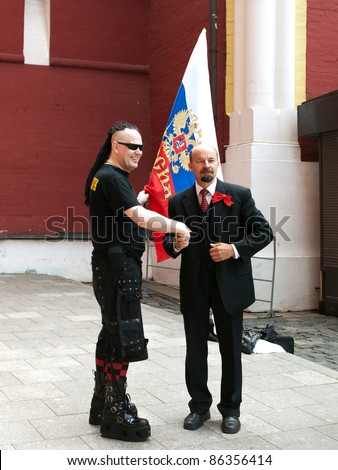 RUSSIA, MOSCOW - JULY 19: Goth and a man in a costume of Lenin shaking hands on Red Square in Moscow on July 19, 2008. Red Square is famous for the resting place of Lenin - Lenin\'s Mausoleum