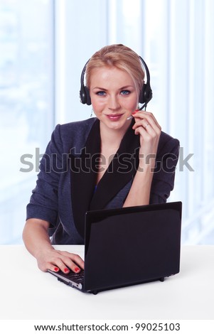 Closeup of a female customer service representative working with headset and laptop. Can I help you?