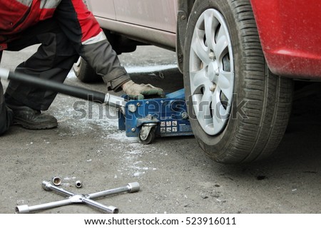 installation of passenger car wheel and replacement on winter tire in winter cloudy day outdoors
