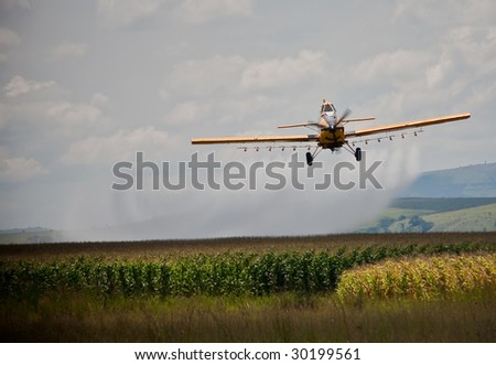 crop sprayer in action over corn field
