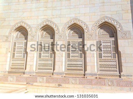 Beautiful arcs with arabic signs of an entrance to the Sultan Qaboos Grand Mosque in Muscat, Oman