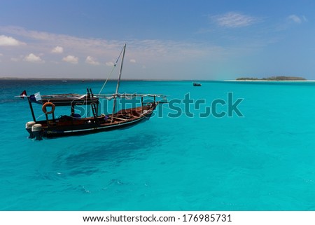 Dhow boat on the amazing turquoise water in the Indian ocean next to Mnemba atoll, Zanzibar, Tanzania