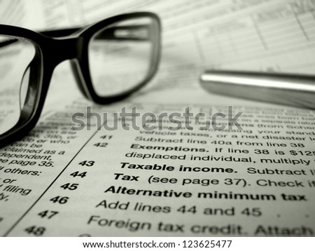 Financial Image Of Some Tax Forms With Glasses And A Pen