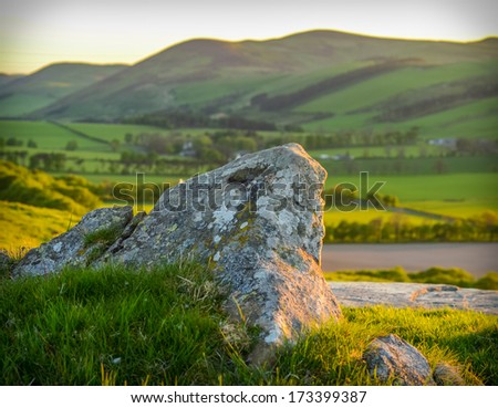 A Rolling Scottish Landscape At Sunset With Rock In Foreground