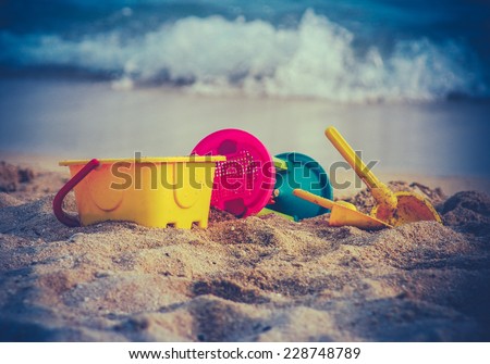 Retro Style Photo Of Children\'s Toys On A Beach With Waves In The Background
