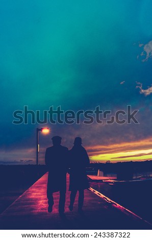 Retro Style Photo Of A Romantic Couple Under A Streetlight At A Marina At Sunset With Copy Space