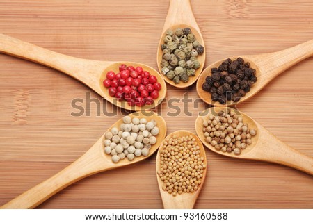Colorful spices in wooden spoons - beautiful kitchen image. black, red green and white pepper, coriander, mustard