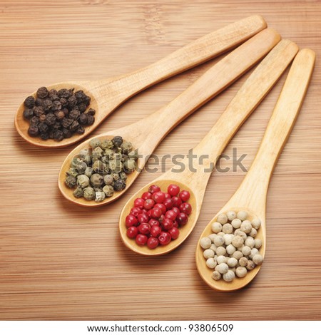 Colorful spices in wooden spoons - beautiful kitchen image. black, red, green and white pepper