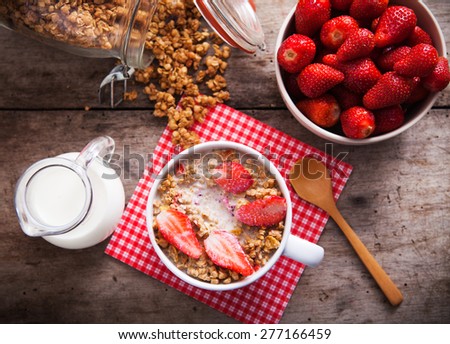 Healthy breakfast. Bowl of milk with granola and strawberries.