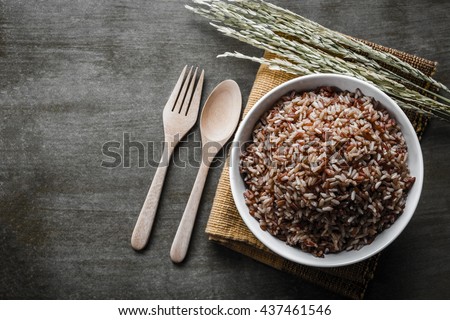Brown Rice/Coarse rice with wooden spoon and fork, rice seed . Top view.