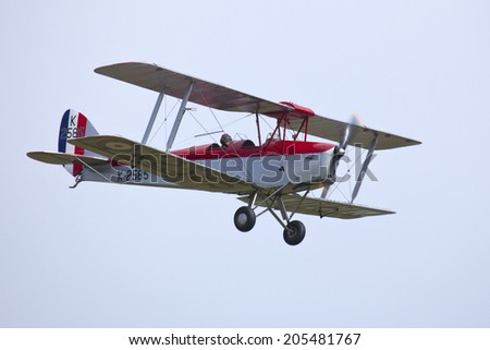 England UK circa 2014 An unamed pilot flies the DH82A Tiger Moth II K2585 G-ANKT BiPlane at a vintage air pageant
